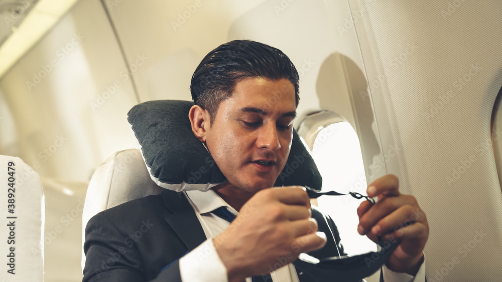 Sleepy businessman travel on a business trip by airplane . Executive traveler concept .