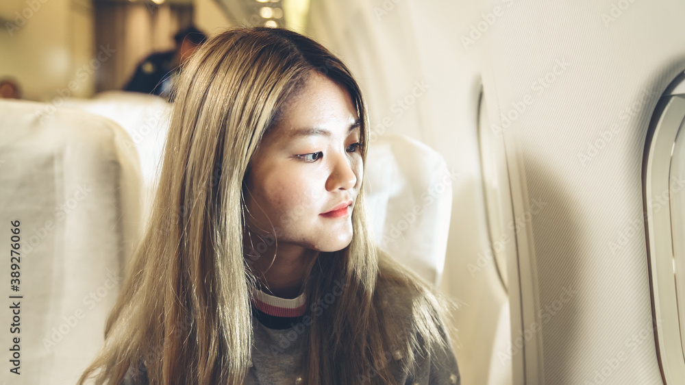 Happy asian woman travel in airplane for vacation tourism .