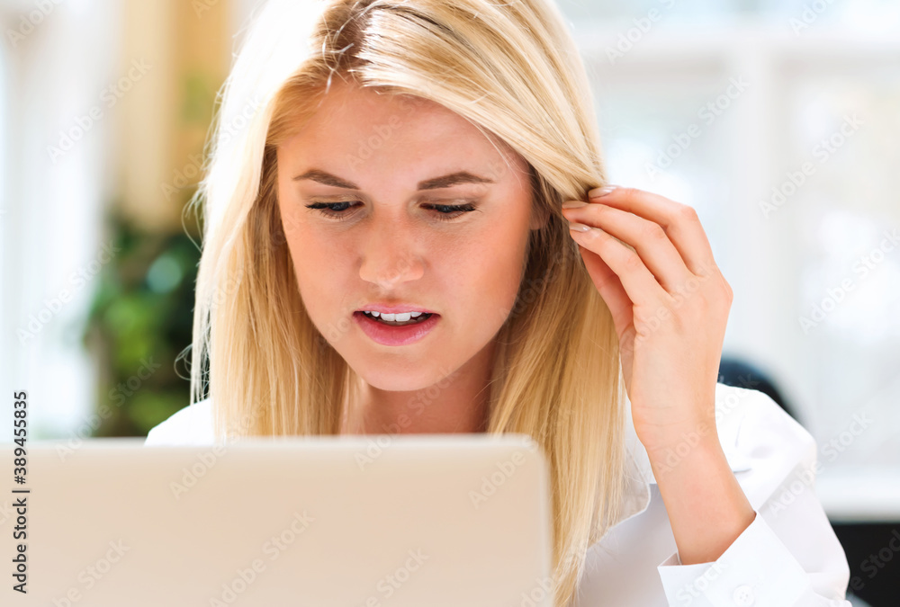 Young woman sitting at her desk in front of the computer