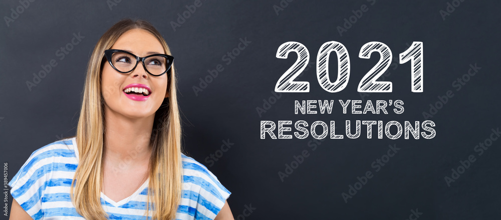 2021 New Years Resolutions with happy young woman in front of a blackboard