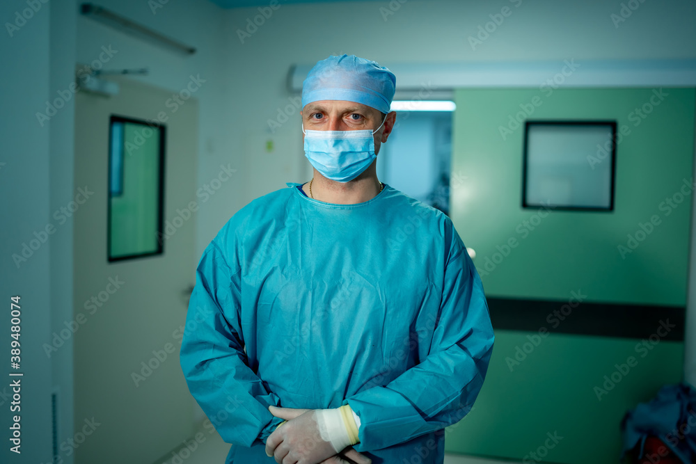 Doctor with medical mask on face. Hospital hall background. Medic in scrubs. Selective focus. Close 