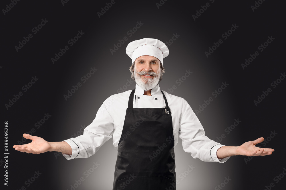 Mature male chef on dark background