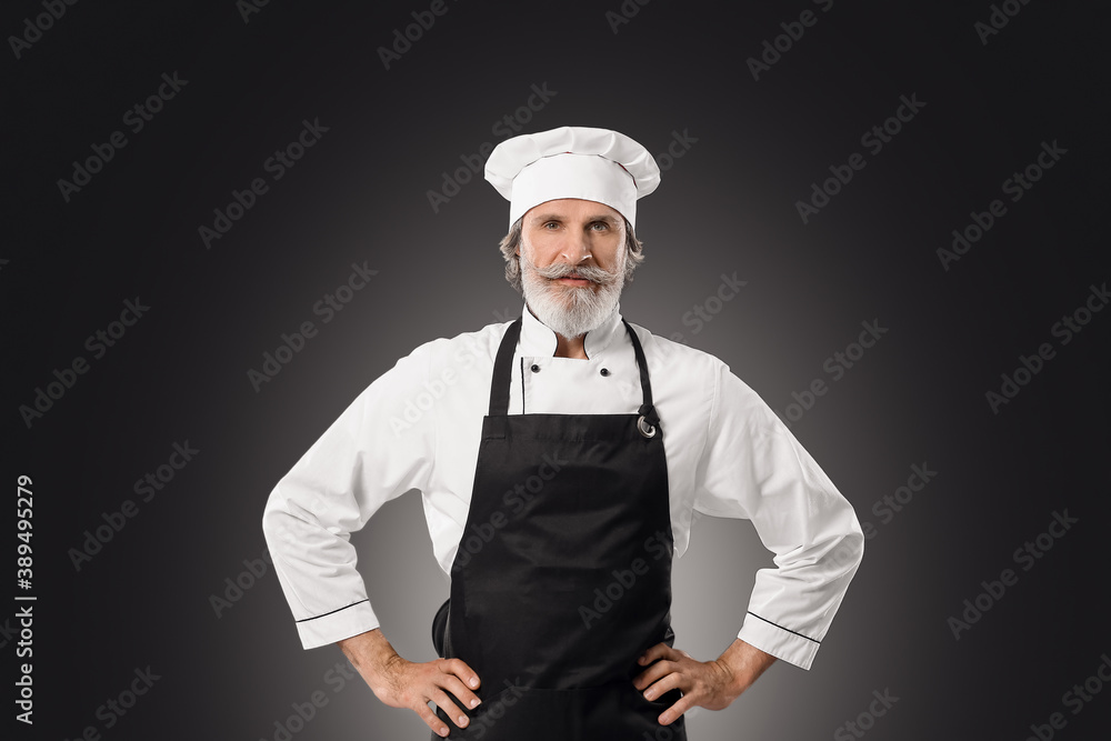 Mature male chef on dark background