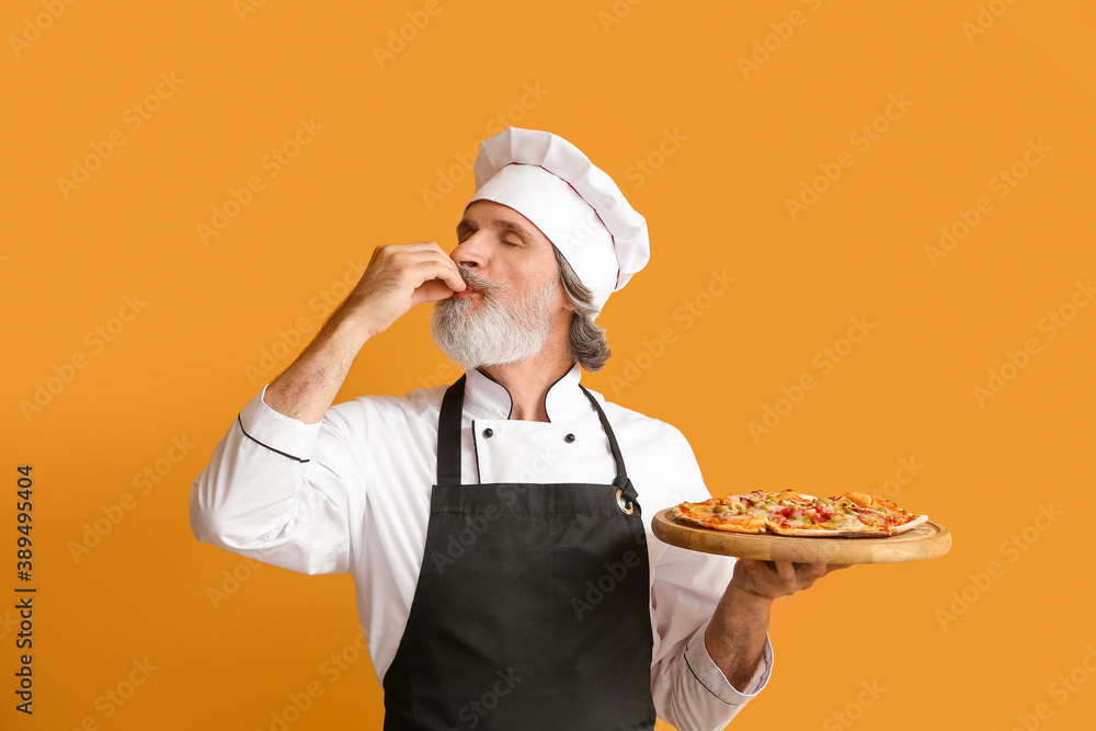 Mature male chef with tasty pizza on color background