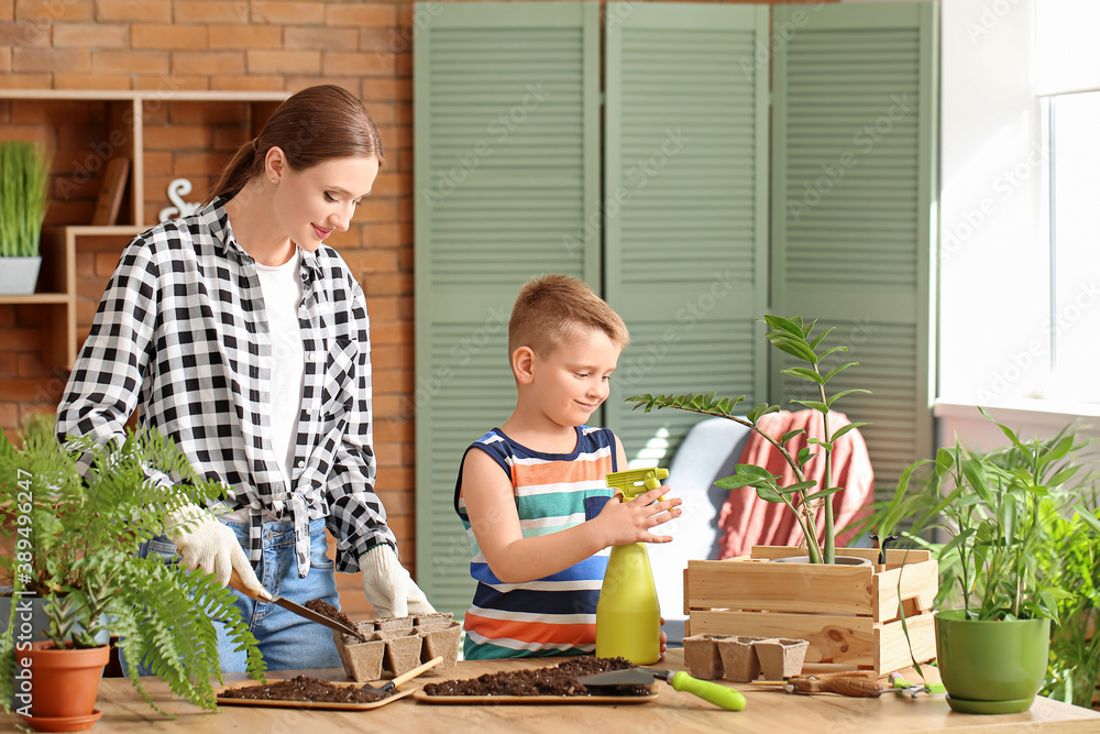 Young mother with son setting out plants at home