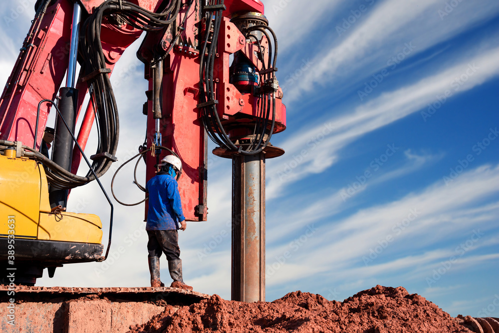 excavator drilling truck with workers in construction site on sky background