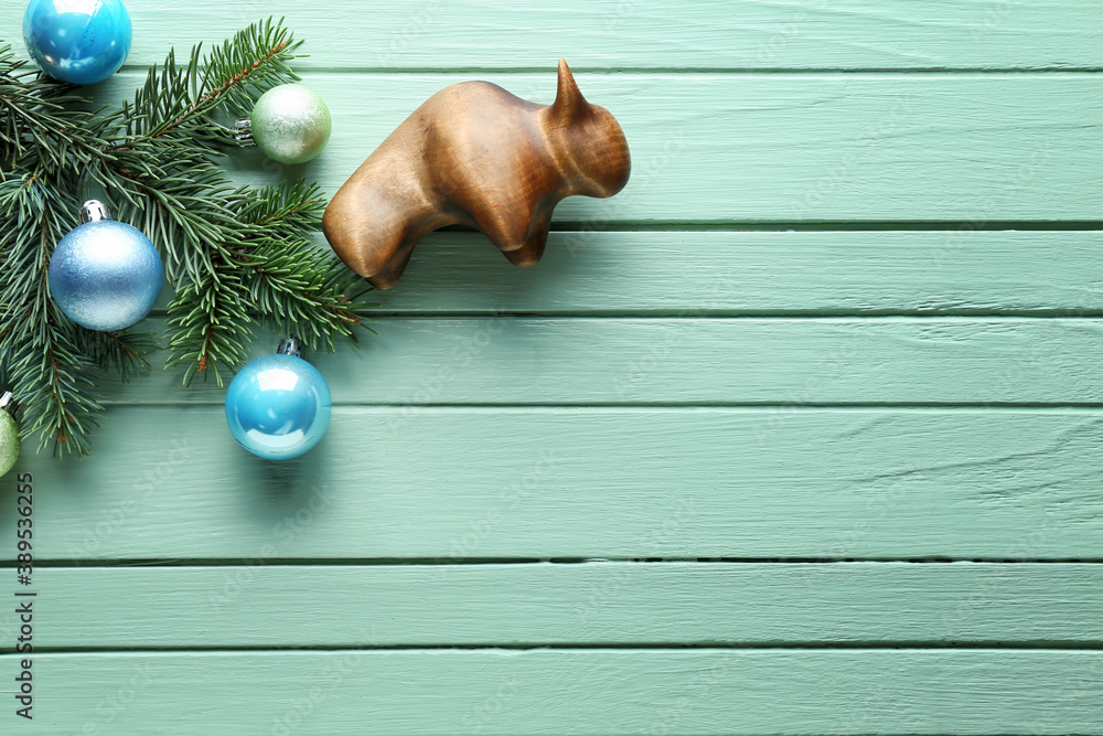 Figurine of bull and New Year decor on wooden background