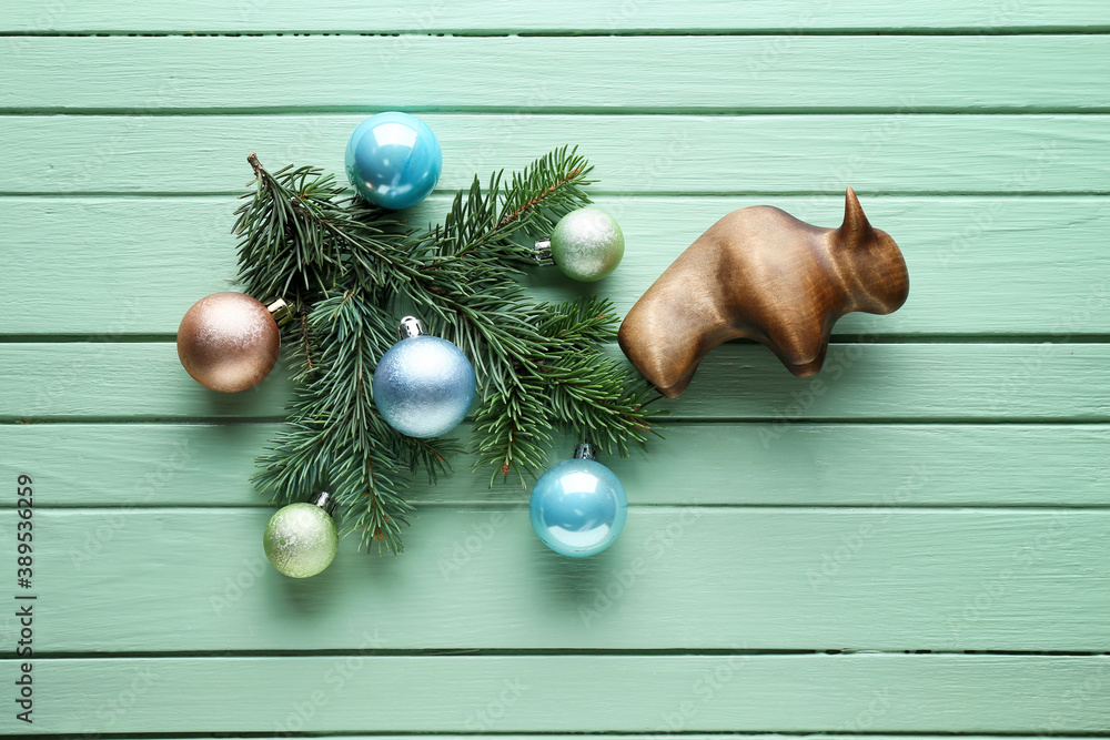 Figurine of bull and New Year decor on wooden background