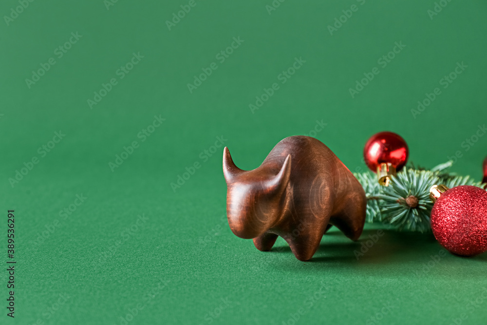 Figurine of bull and New Year decor on color background