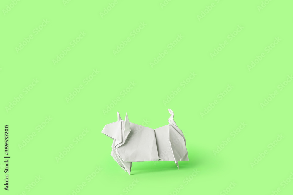 Origami bull as symbol of year 2021 on color background