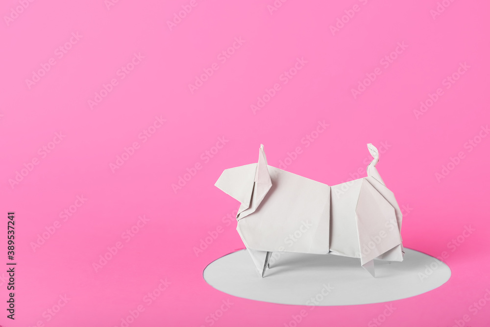 Origami bull as symbol of year 2021 on color background