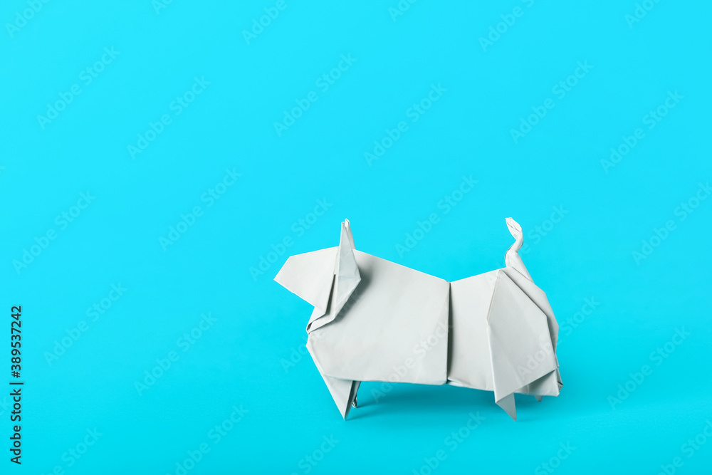 Origami bull as symbol of year 2021 on color background