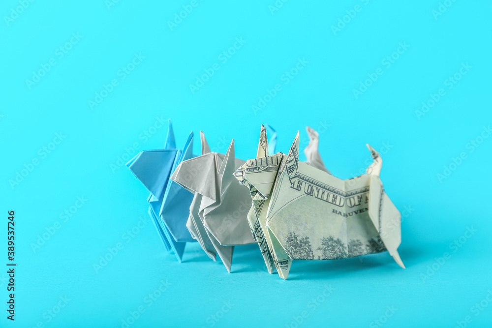 Origami bulls as symbol of year 2021 on color background