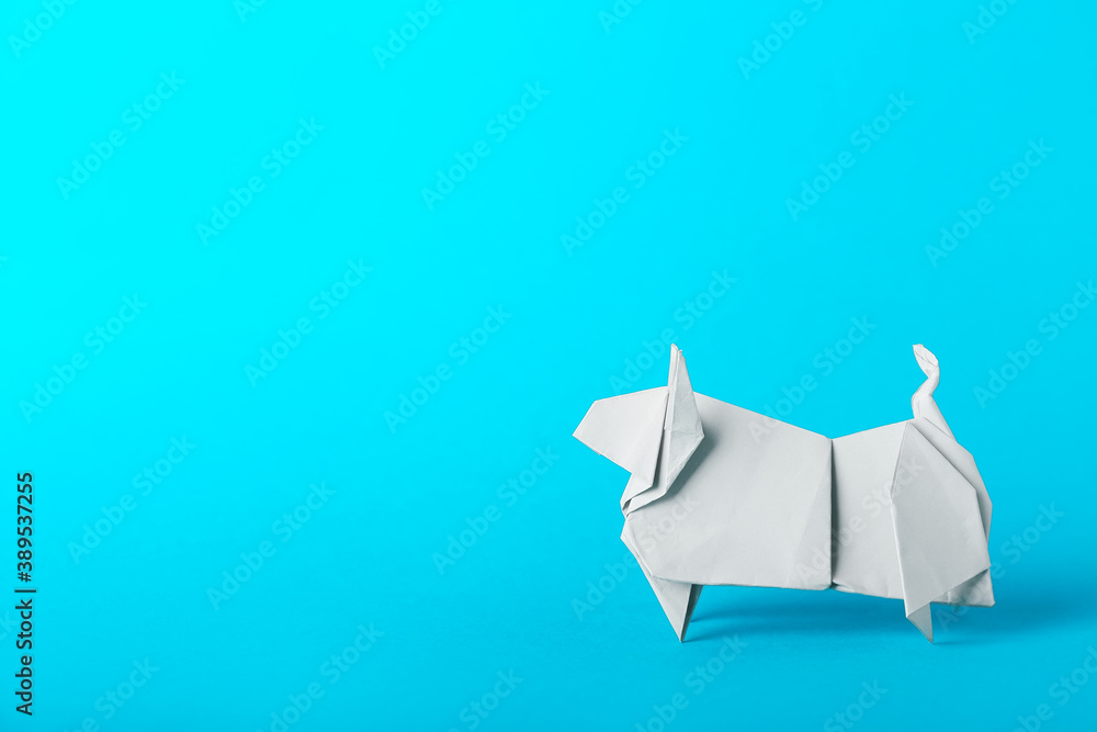 Origami bull as symbol of year 2021 on color background