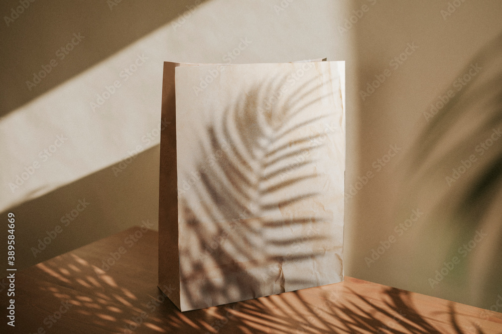 Natural paper bag with palm leaves shadow