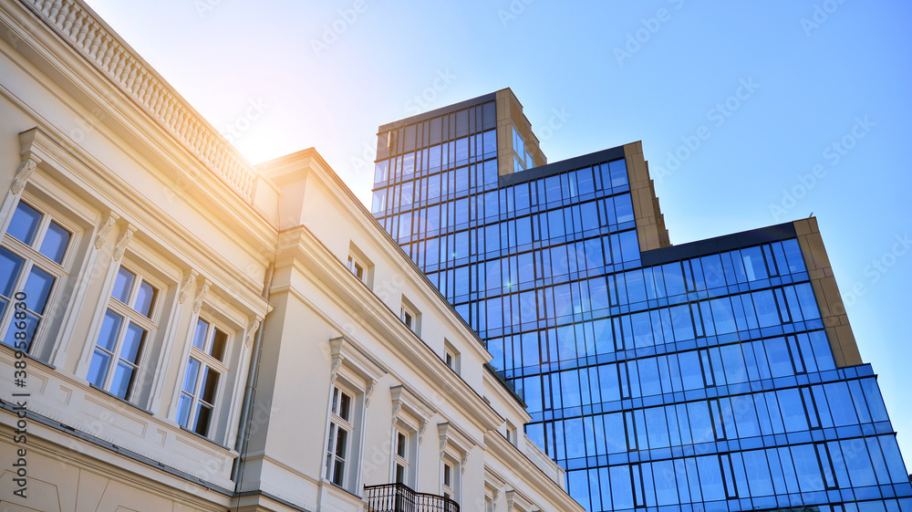 Blue curtain wall made of toned glass and steel constructions under blue sky. A fragment of a buildi