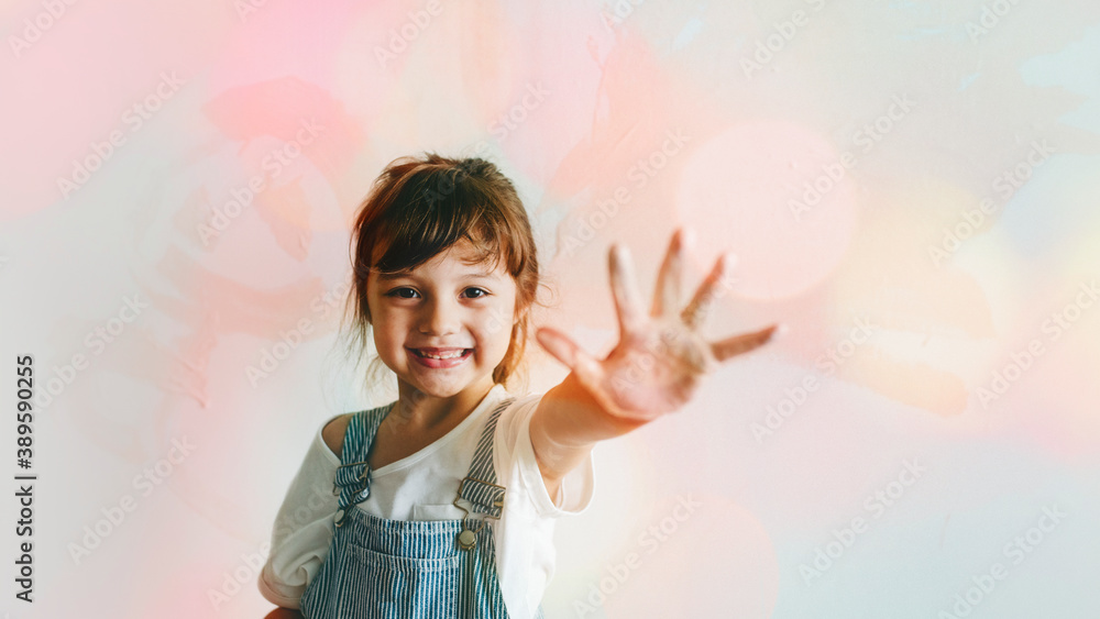 Cheerful girl with a hand covered in paint