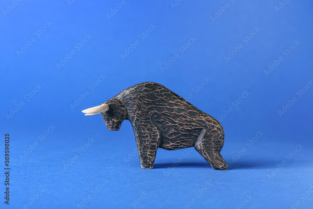 Figurine of bull as symbol of year 2021 on color background