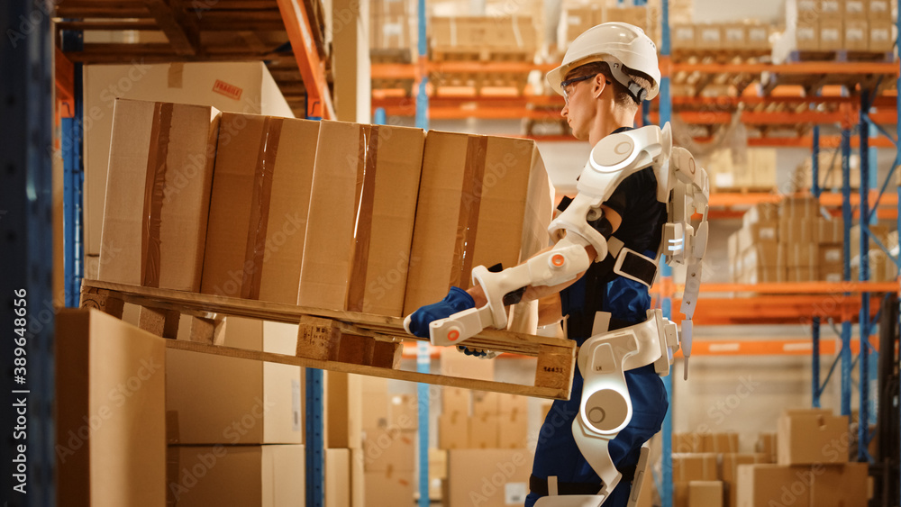 High-Tech Futuristic Warehouse: Worker Wearing Advanced Full Body Powered exoskeleton, Lifts Heavy P