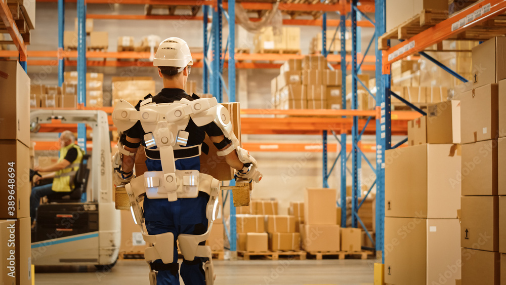 High-Tech Futuristic Warehouse: Worker Wearing Advanced Full Body Powered exoskeleton, Walks with He