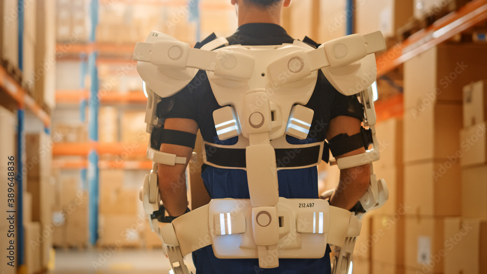 High-Tech Futuristic Warehouse: Worker Wearing Advanced Full Body Powered Exoskeleton, Walks with He