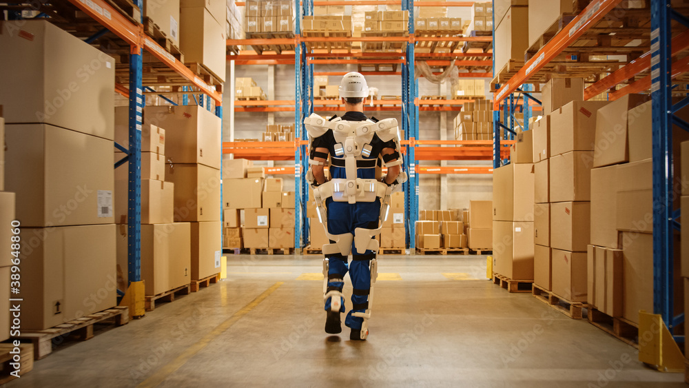 High-Tech Futuristic Warehouse: Worker Wearing Advanced Full Body Powered exoskeleton, Walks with He