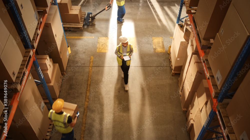 Top-Down View: Worker Wearing Hard Hat Checks Stock and Inventory Using Digital Tablet Computer in t