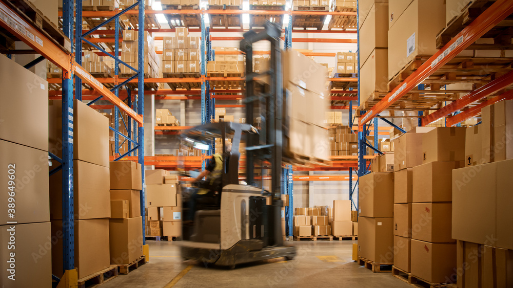 In Warehouse Shot of Blurred Forklift Driving with Pallets Moving Cardboard Boxes with Products from