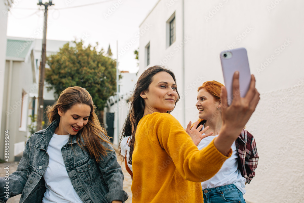 Woman taking a selfie with friends dancing