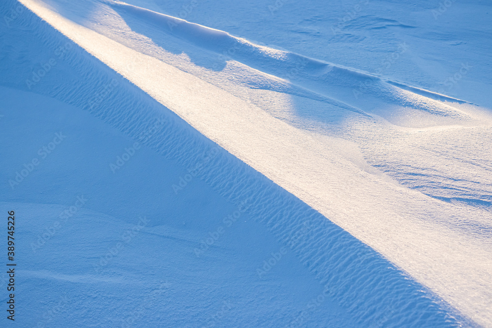 Snow texture. Wind sculpted patterns on snow surface. Wind in the tundra and in the mountains on the