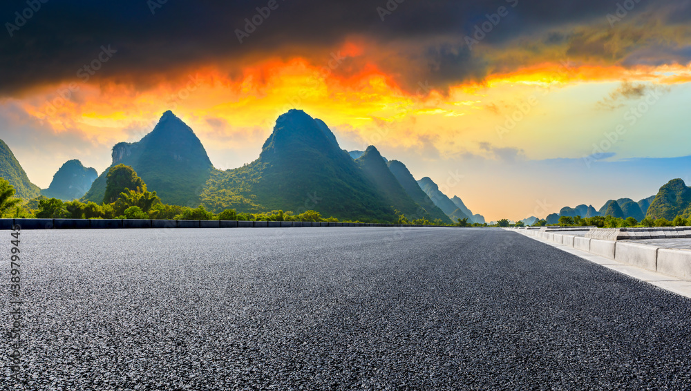 中国桂林日出时的乡村柏油路和青山自然风光。