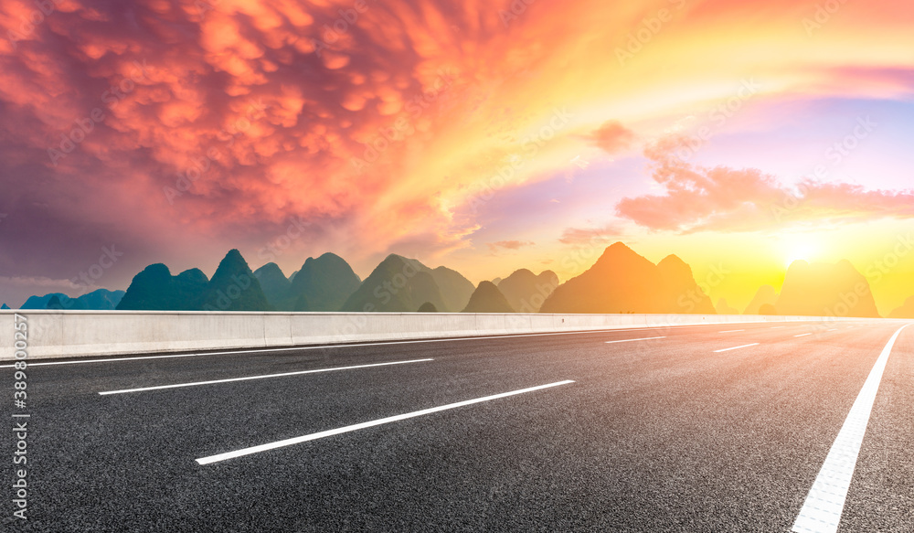 Country asphalt road and green mountain natural scenery in Guilin at sunrise,China.