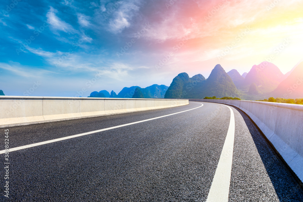 Country asphalt road and green mountain natural scenery in Guilin at sunrise,China.