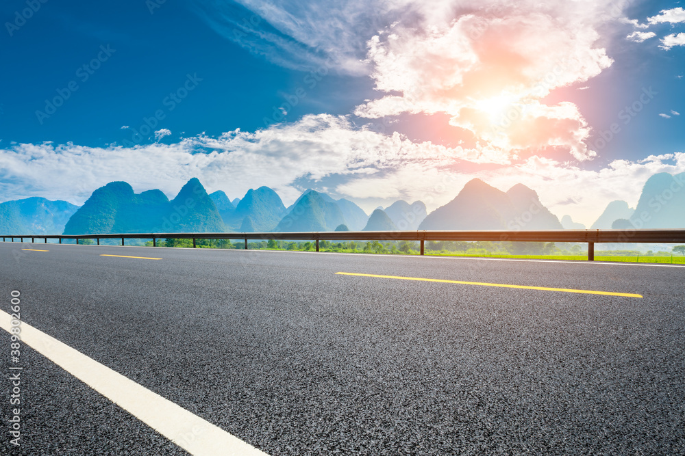 Country asphalt road and green mountain natural scenery in Guilin at sunrise,China.