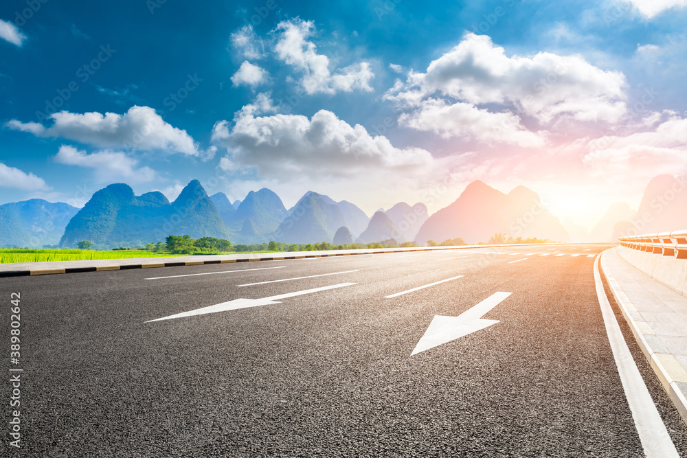 Country asphalt road and green mountain natural scenery in Guilin at sunrise,China.