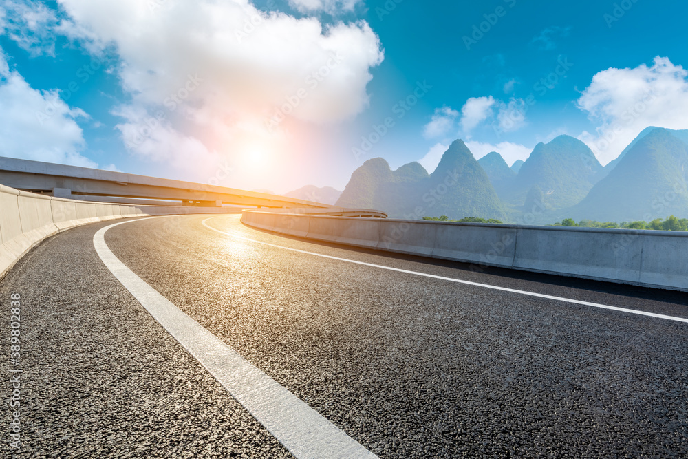 Country asphalt road and green mountain natural scenery in Guilin at sunrise,China.