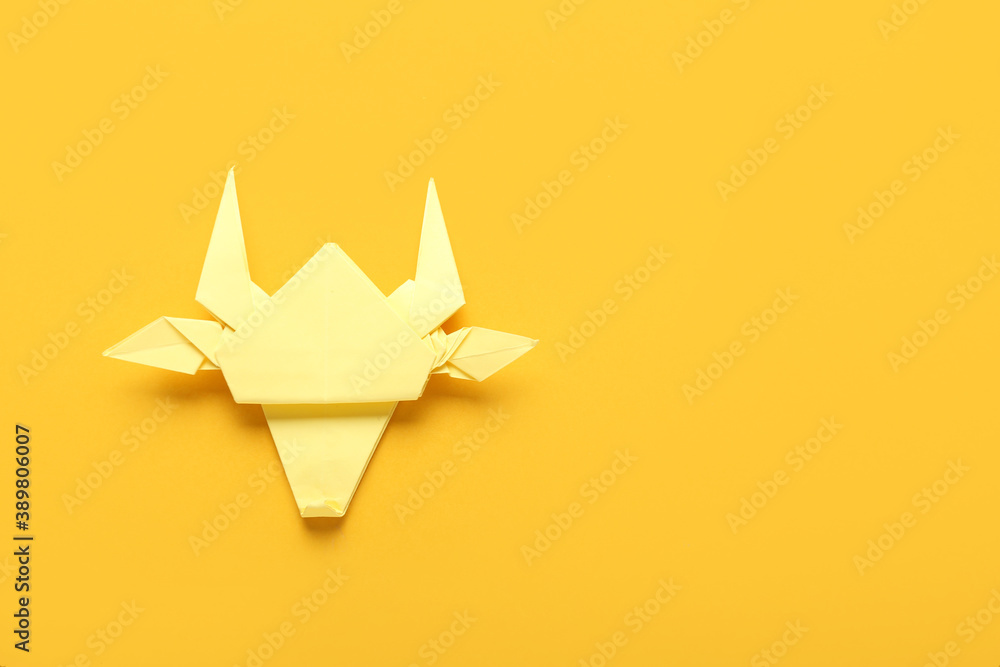 Origami bull as symbol of year 2021 on color background