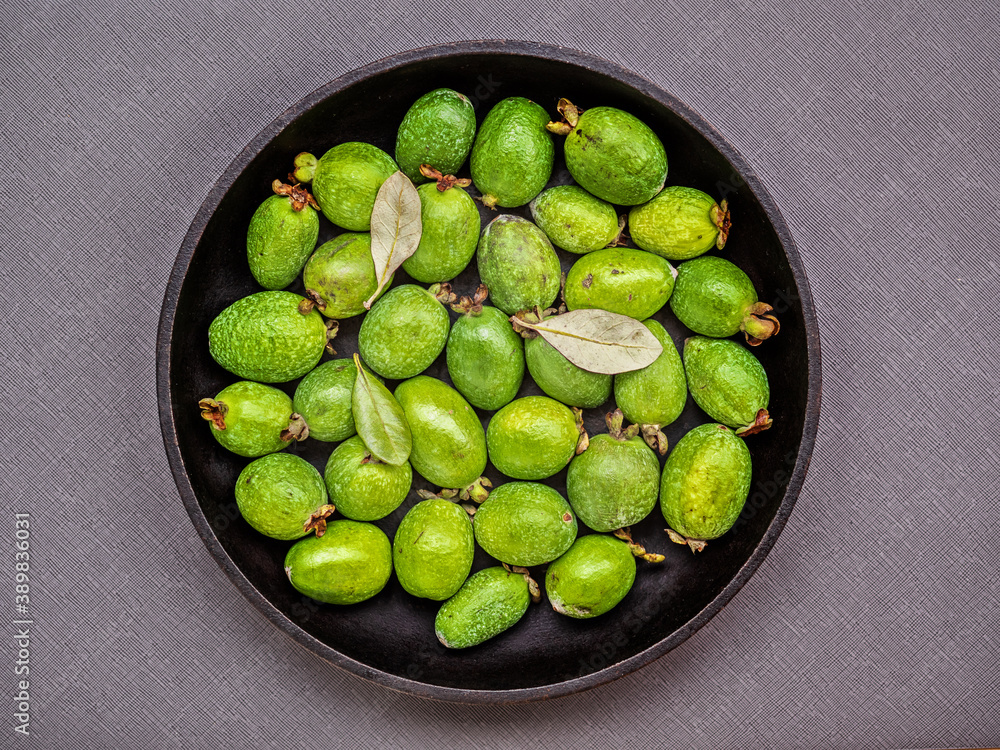 A feijoa fruits (yet known as acca sellowiana) on a dark gray background.
