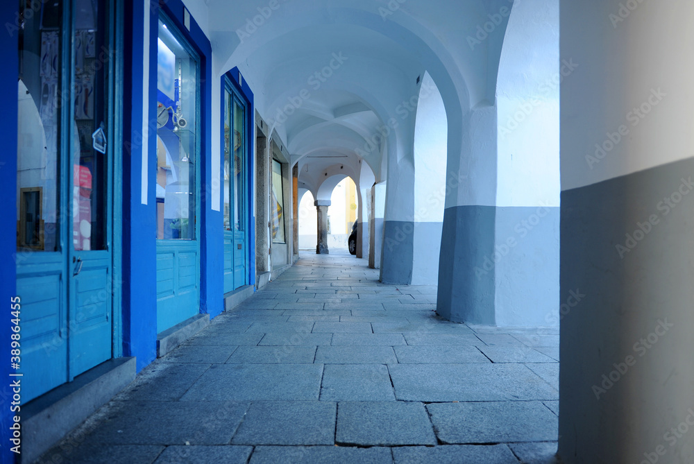 A picturesque street with arcades and small shops in the historic center of the city of Évora, Portu