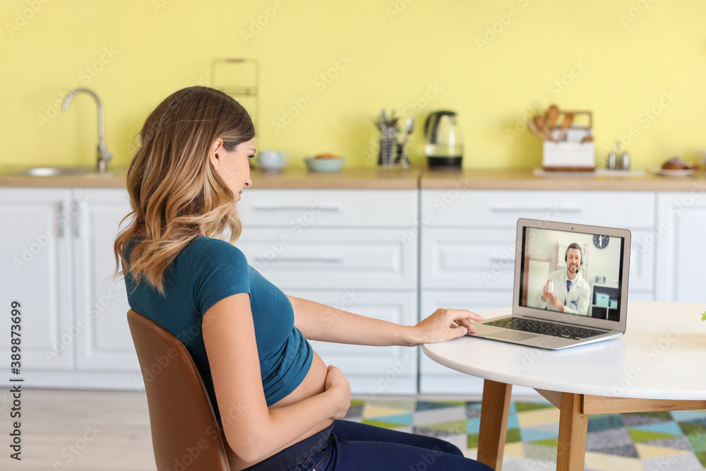 Young pregnant woman video chatting with doctor at home