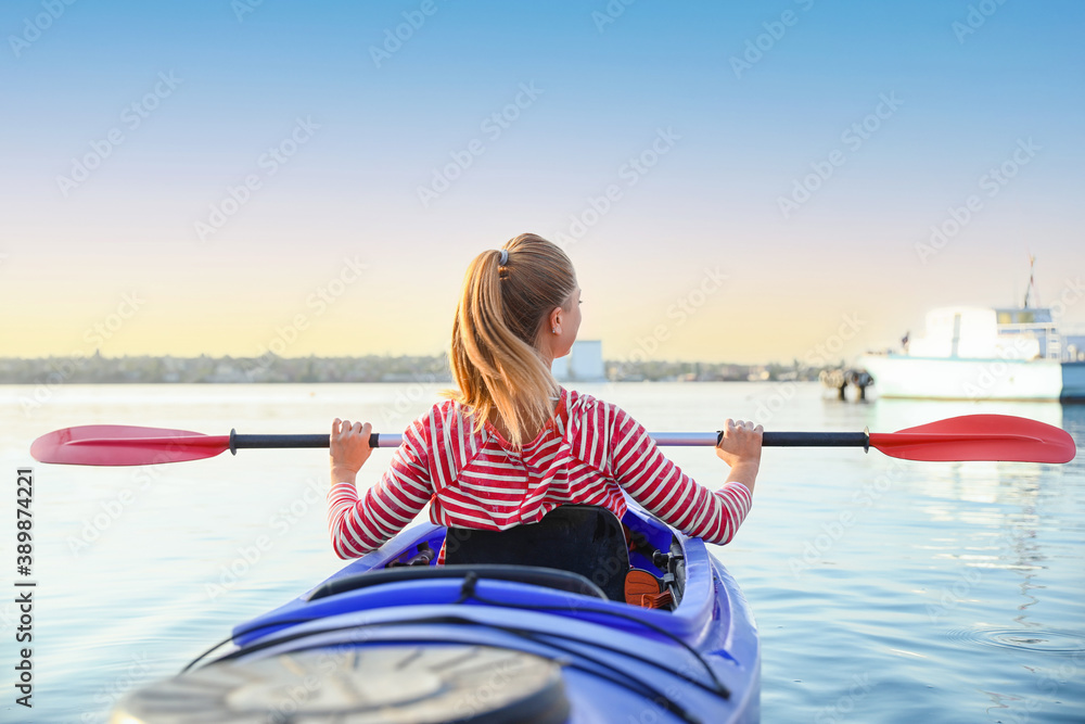 Young woman kayaking in river