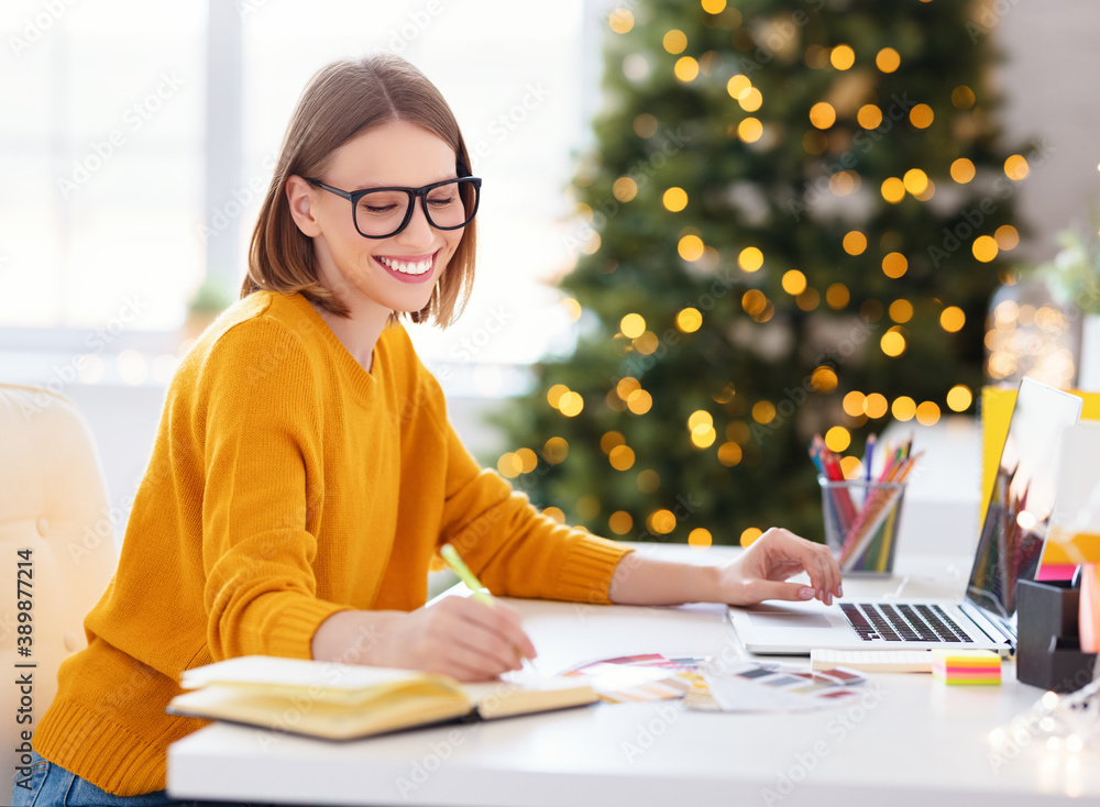 Happy girl freelancer working remote at laptop at home before Christmas.