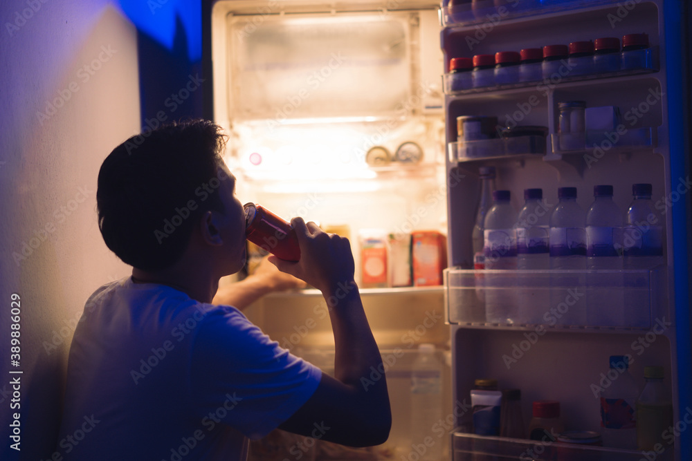  Asian men he is opening the refrigerator.Drink soft drinks at night