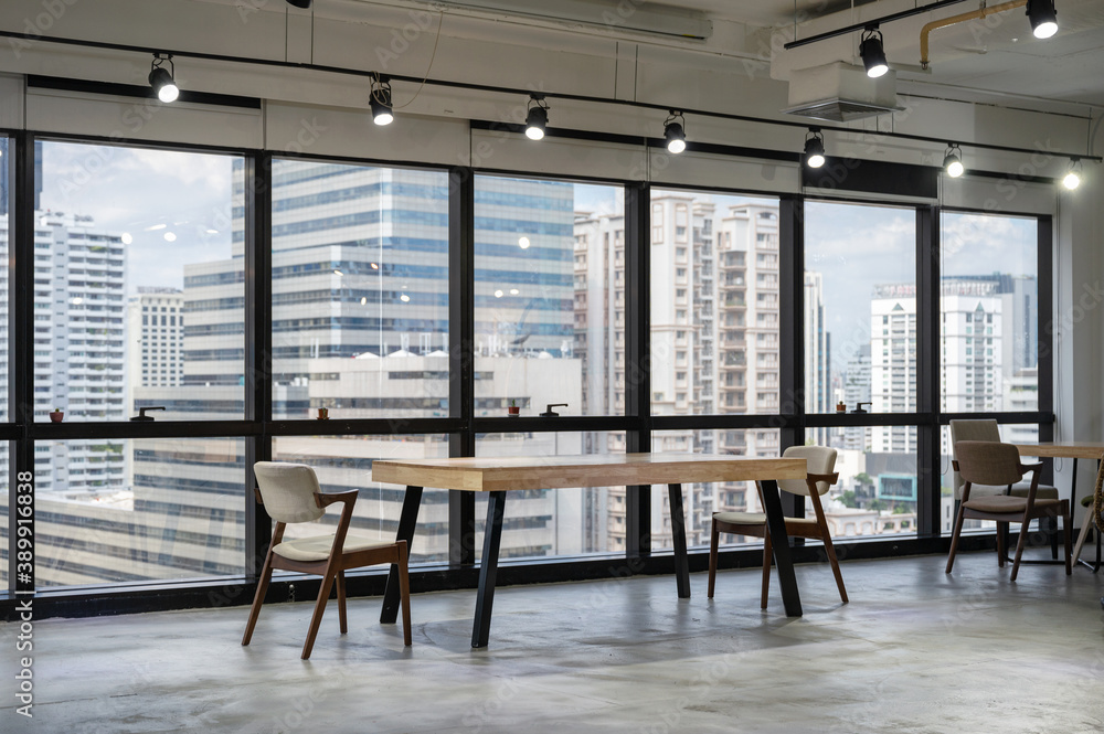 Empty wooden conference table with chairs in coworking space