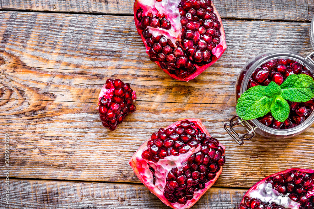 sliced pomegranate on wooden background top view