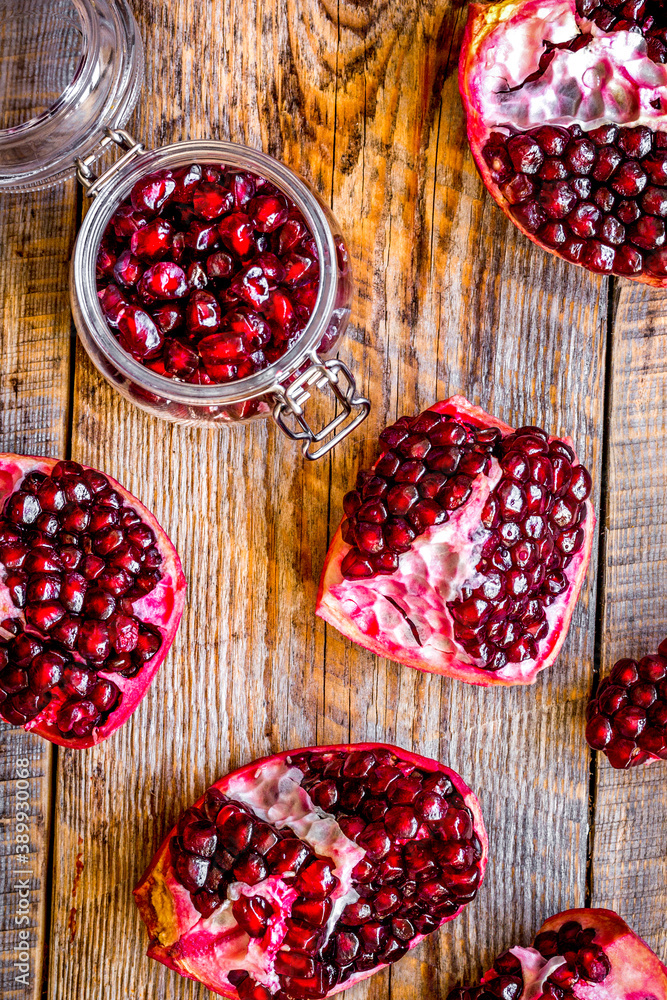 sliced pomegranate on wooden background top view