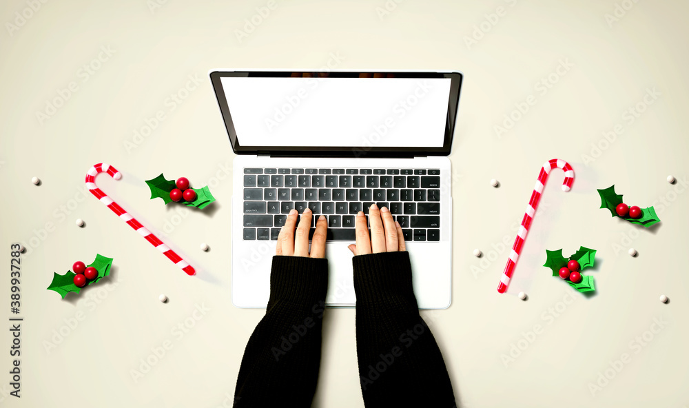 Person using a laptop computer with Christmas decorations from above