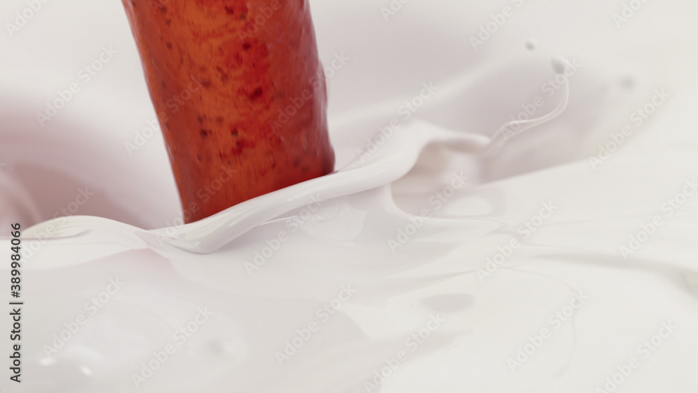 Pouring strawberry topping into milk