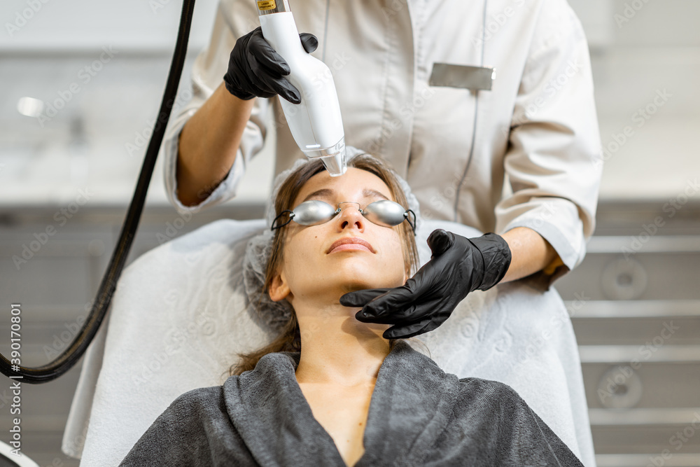 Portrait of a young woman during a facial rejuvenation treatment at medical SPA. LaseMD procedure co