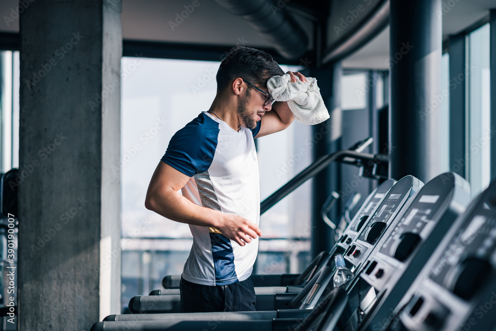 Portrait of muscular sportsman training at modern gym.